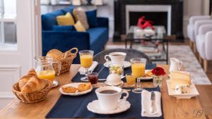 康布雷La Demeure Numéro 5的一张桌子,上面有早餐食品和橙汁