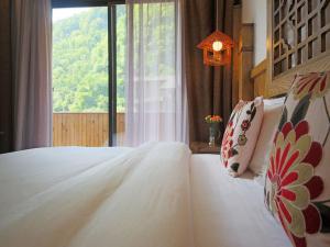 张家界Zhangjiajie One city one inn的卧室配有白色的床和窗户