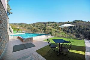 CampomoroneBaia di Campo的一个带桌椅的庭院和一个游泳池