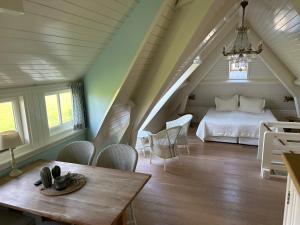 登乌弗Villa Nieuwland B&B的卧室配有一张床和一张桌子及椅子