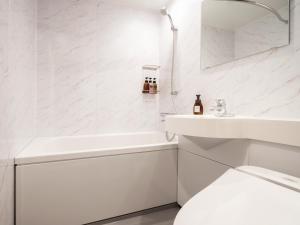 札幌the b sapporo的白色的浴室设有水槽和卫生间。