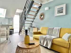 勒芒Le Patio de Loiseau的客厅设有黄色沙发和楼梯。