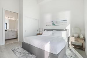坎贝尔河Beachfront Luxury Suite #15 at THE BEACH HOUSE的白色的卧室设有一张大床和一间浴室。