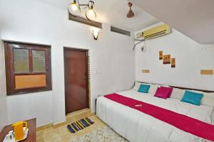 蓬蒂切里Coral Home Stay的卧室配有一张带彩色枕头的大型白色床。