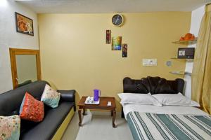 蓬蒂切里Coral Home Stay的客房设有两张床、一张沙发和一张桌子。