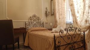 比萨Relais Corso Storico的一间卧室配有一张床、一张书桌和一个窗户。