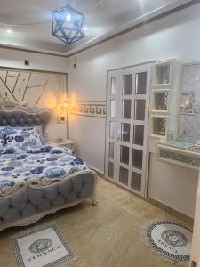 利伯维尔Luxueux platinium的一间卧室配有一张带蓝色和白色棉被的床