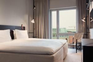 斯德哥尔摩Blique by Nobis, Stockholm, a Member of Design Hotels™的酒店客房设有一张床和一个大窗户