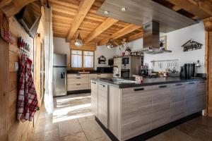 里苏尔Chalet Kala的大型厨房设有木制天花板和木制柜台。
