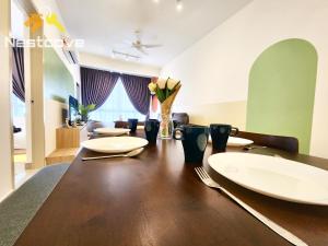 马六甲Mutiara Bali Residence Suites By Nestcove的餐桌上摆放着白色的盘子和鲜花