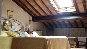 比萨Relais Corso Storico的一间卧室配有一张带桌子和窗户的床
