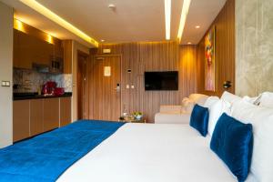 拉巴特First Suites Hôtel的卧室配有带蓝色枕头的大型白色床