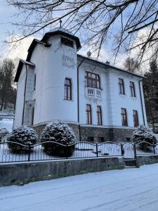 PodbrezováHistorická vila Dom hostí的前面有雪的白色大建筑