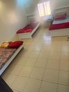 Madain Salehاستراحات ومخيم يمك دروبي的客房铺有瓷砖地板,配有三张床。