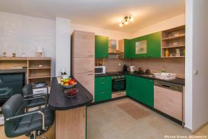 查科韦茨City break apartment的厨房配有绿色橱柜和桌椅