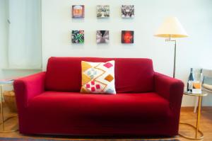都灵Suite Sommeiller Comfort in centro的客厅里配有带枕头的红色沙发