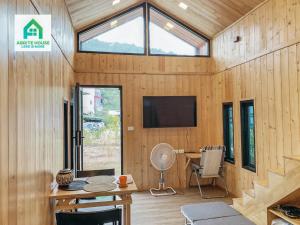 Ban Mo NaeTiny house on Koh Lanta only 2 minutes walk to the beach的一间房子里带桌子和电视的房间