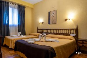 乌娜Hotel Uña Serranía Encantada的两张位于酒店客房的床,配有毛巾