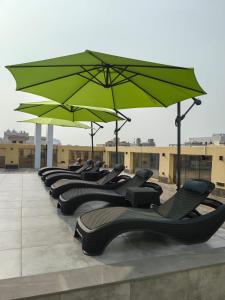 吉达Rosemond Al Hamra的屋顶上一排椅子和遮阳伞