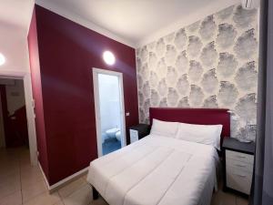 米兰米兰罗索维诺酒店的一间卧室设有一张大床和红色的墙壁