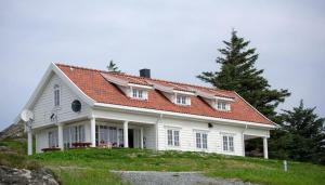 弗洛罗Krokane Camping Florø的山坡上一座白色房子,屋顶橙色