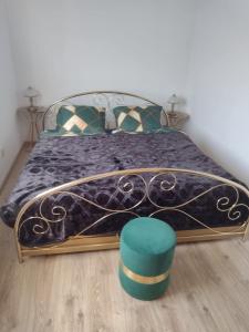 威利兹卡La Casa De Roland的一间卧室配有一张带蓝色毯子和绿色凳子的床