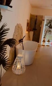 AmayCoco Suite的浴室设有白色浴缸、植物和灯