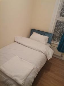 伦敦Nice Single Room near London Seven Kings Train station的一张带白色床单和枕头的床