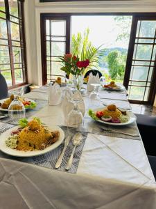 康提Indra Manel Family Holiday Resort Kandy的一张白色桌子,上面放着食物板