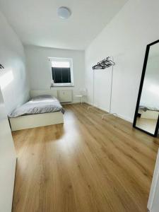 HerscheidFerienwohnung in Herscheid的白色的客房配有床和镜子