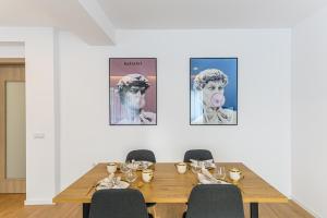 布拉索夫KOA - Davino Aparthotel的配有桌椅和女人肖像的用餐室