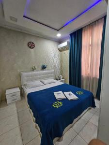 TürkistanLux的一间卧室配有蓝色的床和2条毛巾