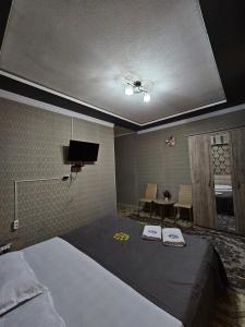 TürkistanLux的一间卧室配有一张床,上面有两条毛巾
