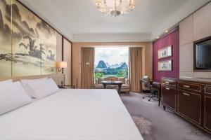桂林桂林香格里拉（亲子酒店 恒温泳池）的一间卧室配有一张床、一张书桌和一台电视