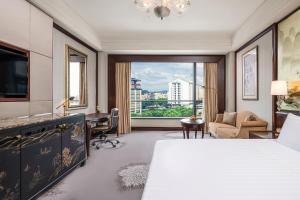 桂林桂林香格里拉（亲子酒店 恒温泳池）的一间卧室配有一张床、一张书桌和一个窗户。