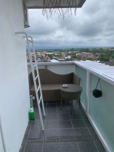 日惹2BR VIVO Apartement by MJP的阳台设有长凳、梯子和桌子