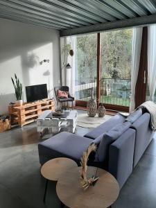 WingeneWoning gelegen in rustige bosrijke omgeving的客厅配有蓝色的沙发和桌子