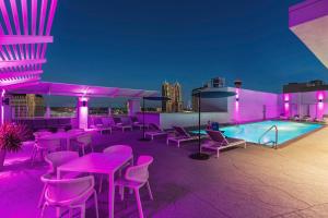 圣安东尼奥Hilton Garden Inn San Antonio Downtown Riverwalk的一个带粉红色桌椅的屋顶露台和游泳池