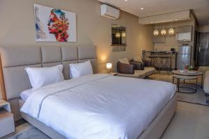 玛丽娜斯米尔PLAYA DEL PACHA Suites Hotel的一间带白色大床的卧室和一间客厅