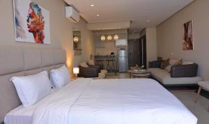 玛丽娜斯米尔PLAYA DEL PACHA Suites Hotel的一间带白色床的卧室和一间客厅