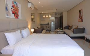玛丽娜斯米尔PLAYA DEL PACHA Suites Hotel的一间带白色大床的卧室和一间客厅