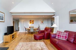 圣安德鲁斯Kilrymont View的客厅配有红色的沙发和桌子