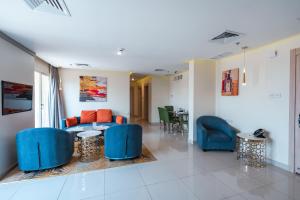 科威特Wahaj Boulevard Hotel Apartmentوهج بوليفارد للشقق الفندقية的客厅配有蓝色椅子和沙发