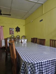 卡齐兰加Shivaji Inn Kaziranga的一间设有蓝白格子桌的用餐室