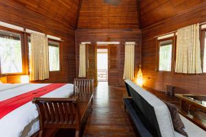 雅加达RedDoorz Resort @ Taman Wisata Mangrove的一间卧室,卧室内配有一张床和椅子