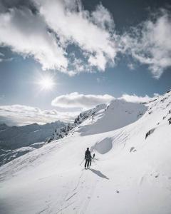 LyngværetLuksushytte med Jacuzzi, Summer&Winter Retreat的一个人在雪覆盖的山里滑雪