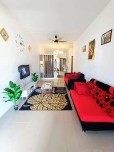 古晋ASFA Homestay Kuching的客厅配有红色沙发和电视