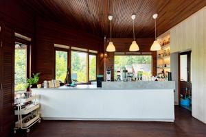雅加达RedDoorz Resort @ Taman Wisata Mangrove的厨房配有白色的柜台和一些窗户。