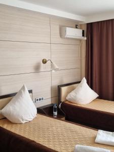 AksayОтель Бестау的酒店的客房 - 带2张带白色枕头的床