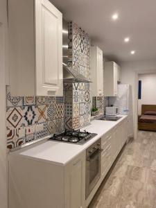 圣保罗湾城Beach House. Live, experience sea的厨房配有白色橱柜和炉灶烤箱。